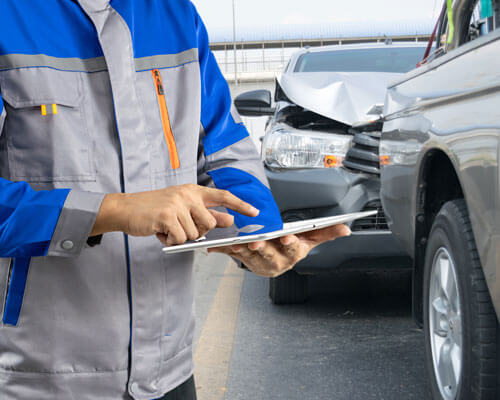 Insurance officer examining car after accident