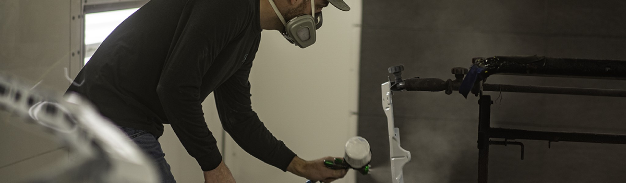 Man Spraying Paint Onto Part